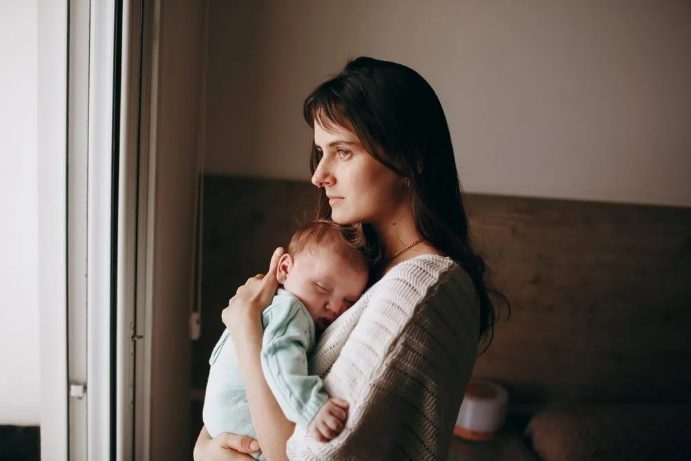 A mother holding a newborn in soft light